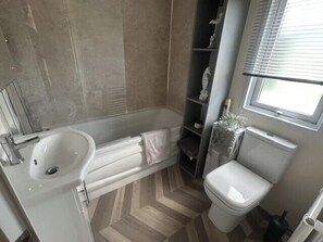 Une salle de bain avec un lavabo, des toilettes et une douche.