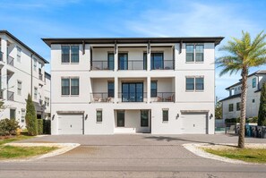 Ein mehrgeschossiges Wohngebäude mit flacher Fassade, Balkonen und einem verschlossenen Eingang.