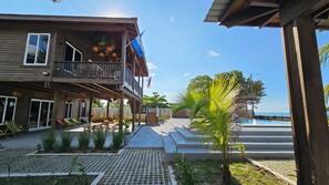 A wooden building with a balcony, a flag, and a pool area.
