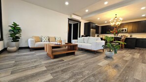 A modern living room with a sofa, coffee table, and potted plants.
