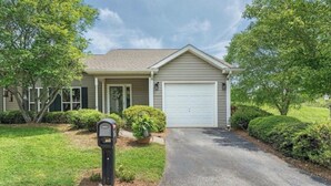 A residential house with a garage, a driveway, and a mailbox. - Adorable 2-bedroom condo in charming Arden near airport (arden)
