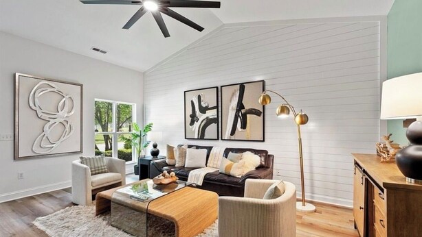 A modern living room with a sofa, armchairs, a coffee table, and artwork on the walls. - Adorable 2-bedroom condo in charming Arden near airport (arden)