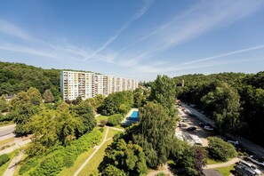 Een woonwijk met een groot appartementencomplex, een tennisbaan en een parkeerplaats.