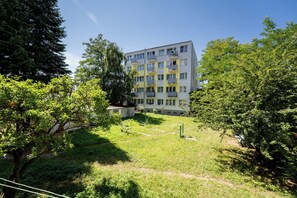 A multi-story residential building with balconies, surrounded by trees and a grassy area with exercise equipment. - Brzeźno Beachside Studio (Gdańsk)