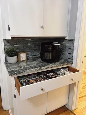 A kitchen with a built-in coffee maker, a drawer with various food items, and a potted plant. - Private Cozy Room - 5 min to Hospital and Main in Fredericksburg TX 1 (Fredericksburg)