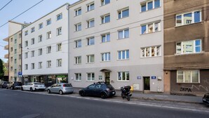 Un immeuble à plusieurs étages, doté d’une façade plate, de nombreuses fenêtres et d’une entrée au niveau du sol.