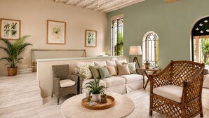 A room with a ceiling fan, a sofa, a wicker chair, and framed botanical prints on the wall. - Luxurious & Secure Private Pool Villa in Cap Estate, St. Lucia 3 BR+3 Bathrooms (Gros Islet)