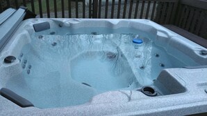 Ein Whirlpool mit Steinverkleidung, eingebauten Düsen und einem Ablauf.