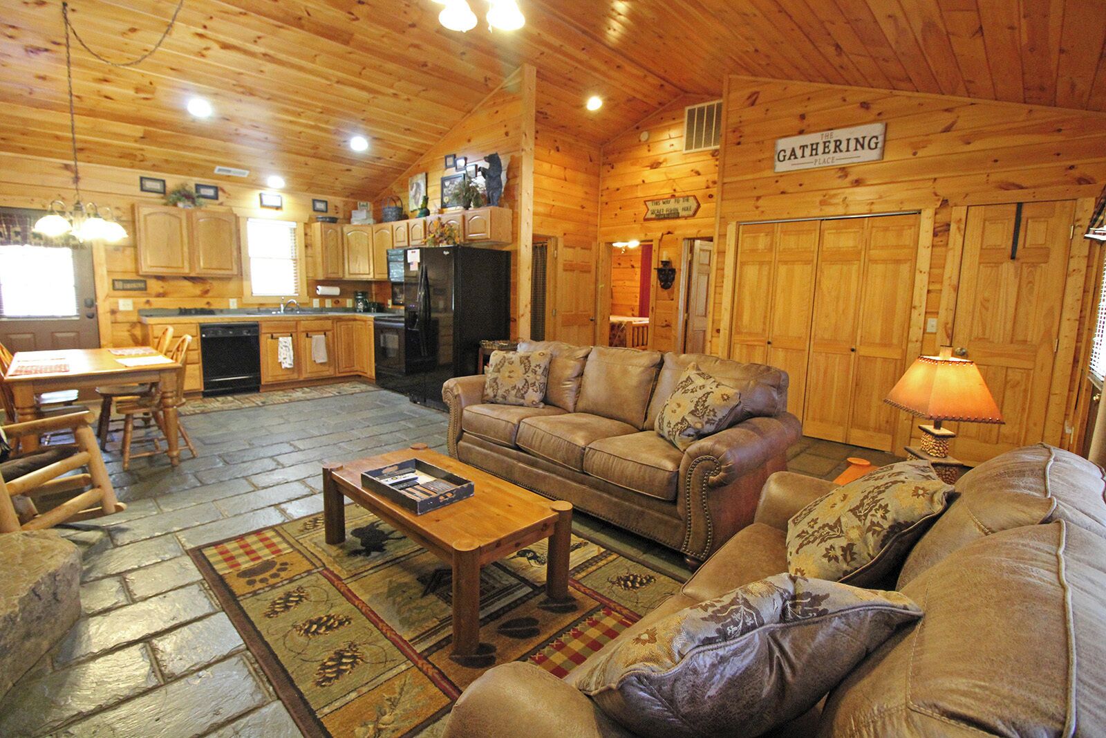 Un intérieur de chalet chaleureux comprenant un salon, un coin repas et une cuisine.