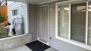 A residential entryway with a sliding glass door, a concrete step, and a black doormat. - A bright, clean walking-out basement unit in Surrey,near White-rock. (Surrey)