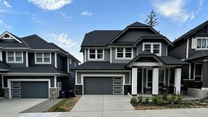 A residential area with modern houses, a central driveway, and a clear sky. - A bright, clean walking-out basement unit in Surrey,near White-rock. (Surrey)