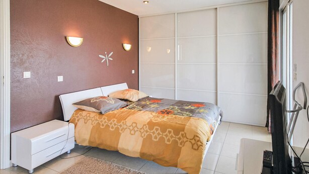 A bedroom with a bed, bedside tables, a wardrobe, and a television. - Gorgeous home in FREJUS with private swimming pool, can be inside or outside (FREJUS)