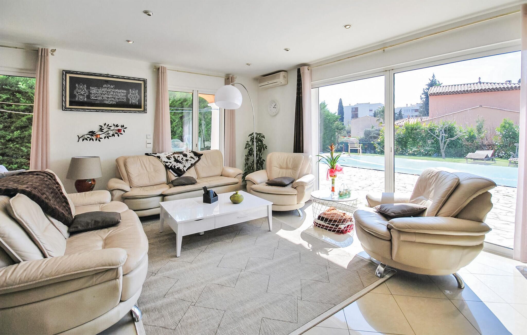 A modern living room with a sofa set, a coffee table, and a view of the outdoors.