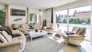 A modern living room with a sofa set, a coffee table, and a view of the outdoors. - Gorgeous home in FREJUS with private swimming pool, can be inside or outside (FREJUS)