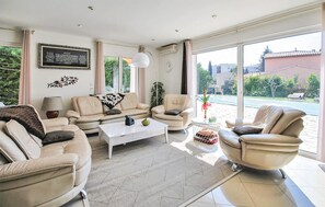 Ein modernes Wohnzimmer mit einer Sofagarnitur, einem Couchtisch und Blick ins Freie.