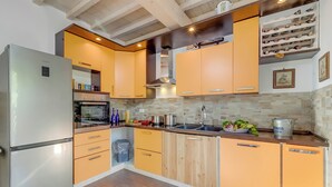 Eine moderne Küche mit einem Edelstahlkühlschrank, Holzschränken und einem Weinkühlschrank.