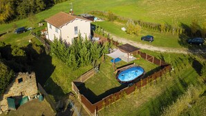 Ein Haus mit Swimmingpool, einem umzäunten Garten und einer kleinen Grünfläche.