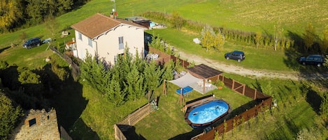 A house with a swimming pool, a fenced yard, and a small garden area.