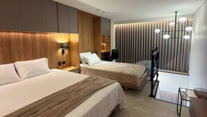 Ein modernes Hotelzimmer mit zwei Betten, einem Schreibtisch und einem großen Fenster mit Vorhängen.