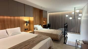Une chambre d’hôtel moderne avec deux lits, un bureau et une grande fenêtre avec des rideaux.