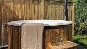 Ein Whirlpool mit Handtuch, zwei Gläsern und einem dekorativen Behälter.