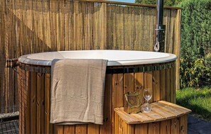 Ein Whirlpool mit Handtuch, zwei Gläsern und einem dekorativen Behälter.