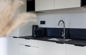 A modern kitchen with a black countertop, stainless steel sink, and a coffee machine. - Awesome home in Voorthuizen with WiFi (Voorthuizen)
