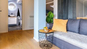 Een moderne woonkamer met een bank, een rond salontafel en uitzicht op de keuken.