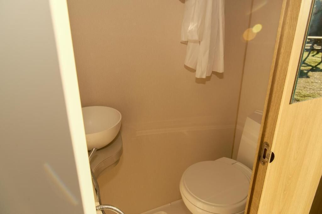 Un baño pequeño con inodoro, lavabo y ducha.