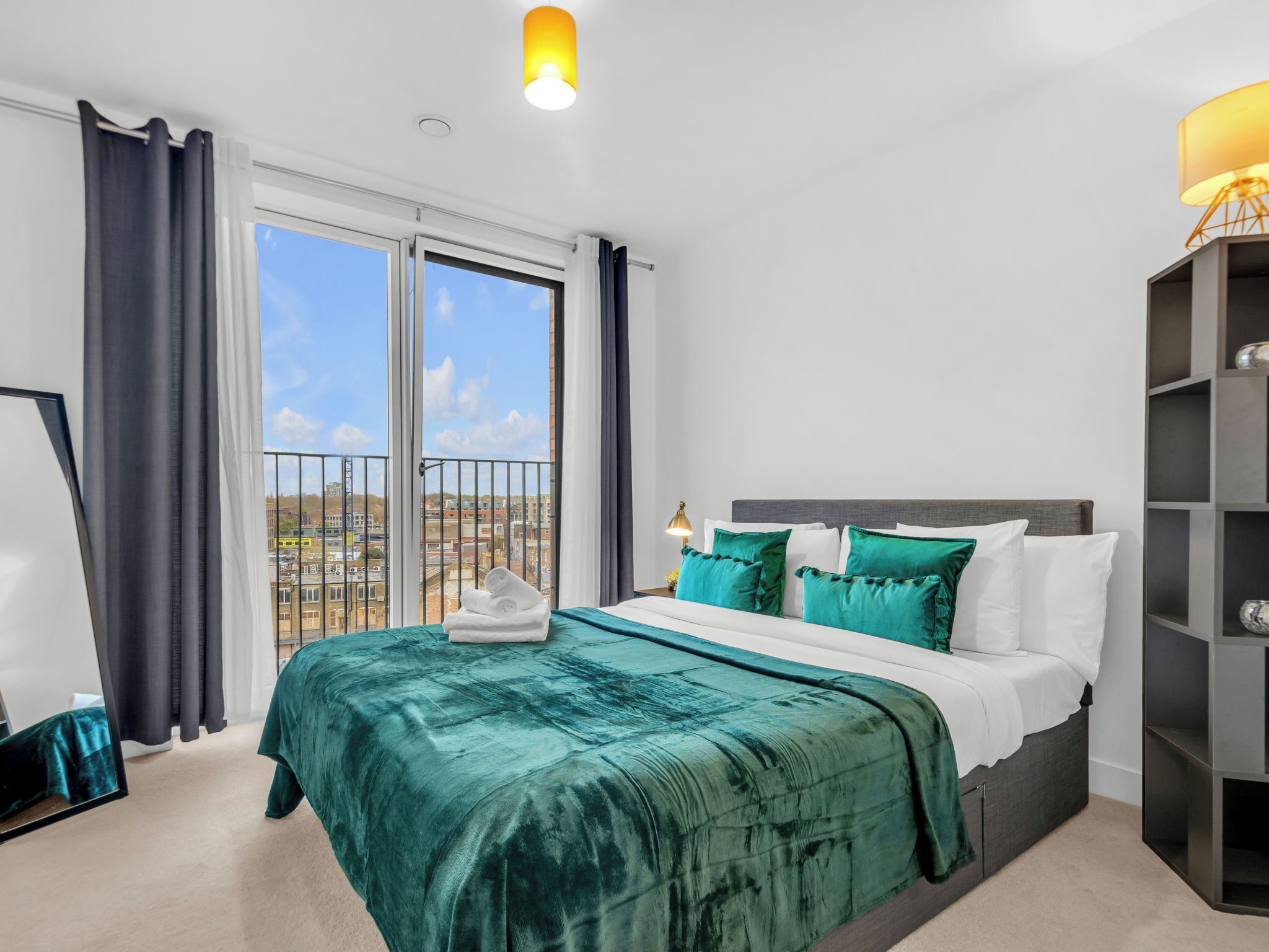 Une chambre d’hôtel avec un grand lit, une vue sur la ville et un balcon.