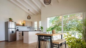 Una cocina moderna con una isla central, electrodomésticos de acero inoxidable y una zona de comedor con banco.