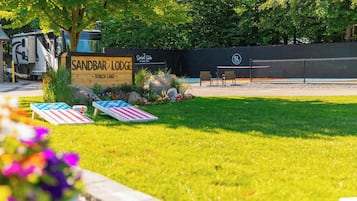 A sign for Sandbar Lodge with a pool area, outdoor seating, and a fenced enclosure.