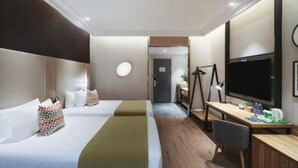 A hotel room with two beds, a desk, a chair, a TV, and a mirror. - Campanile Hotel (Huaibei)