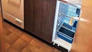 Een keuken met een ingebouwde oven, een spoelbak en een koelkast.