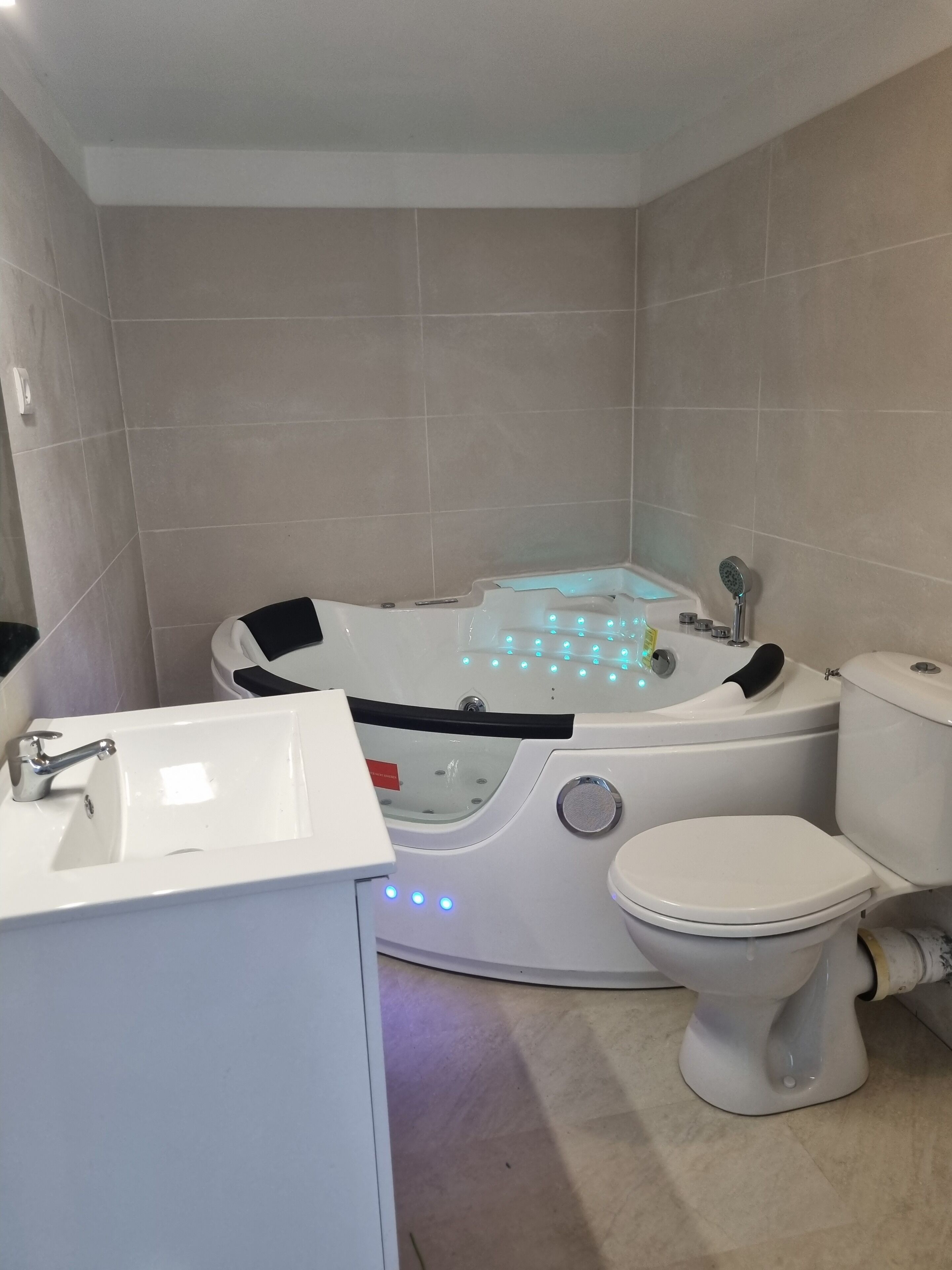 A modern bathroom with a bathtub, toilet, and sink.