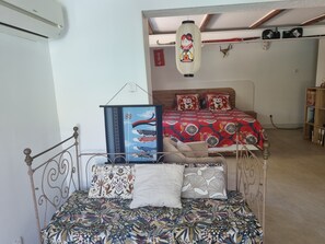 Ein Schlafzimmer mit einem Bett, Kissen, einer hängenden Laterne und einem Bücherregal.