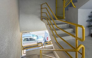A staircase with yellow handrails leading to a lower level.
