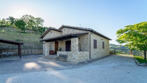 Una casa de piedra con un patio, una puerta y una ventana.