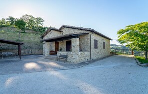 A stone house with a patio, a door, and a window. - Lovely home in San Severino Marche (San Severino Marche)