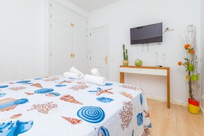 Ein Hotelzimmer mit einem Bett, einem Schreibtisch, einem Fernseher und einer Pflanze.