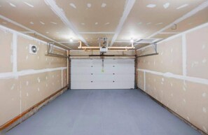 A garage with a closed garage door, a ceiling fan, and recessed lighting. - Modern Windermere Home | Sleeps 6 | Near Shopping & Airport (Edmonton)