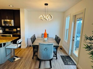 A modern kitchen with dark cabinets, a stainless steel refrigerator, and a built-in oven. - Modern Windermere Home | Sleeps 6 | Near Shopping & Airport (Edmonton)