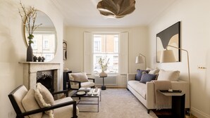 Ein Wohnzimmer mit Kamin, einer Couch, einem Couchtisch und einer Lampe.