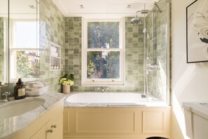 A bathroom with a large window, a bathtub, and a shower. - Luxury 3 Bedroom Kensington Townhouse With Private Garden (London)
