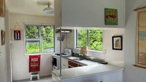 Une cuisine avec une fenêtre, une cuisinière et un évier.