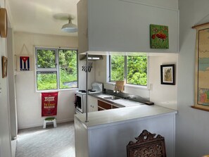 Eine Küche mit Fenster, Herd und Spüle.