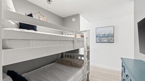 Camera con letto a castello, una cassettiera e un quadro appeso al muro.