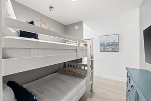 Ein Zimmer mit Etagenbetten, einem Schminktisch und einem Bild an der Wand.