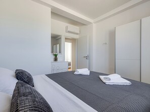 Ein Hotelzimmer mit Bett, Schminktisch, Spiegel und Tür.