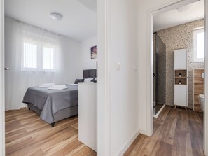 A bedroom with a bed, bedside table, and a window with sheer curtains. - Vila Nik by Interhome (Zadar/Sukošan)